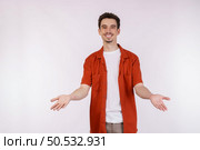 Portrait of puzzled clueless young man arms out asking why what’s the problem who cares so what, I don’t know on isolated background. Стоковое фото, агентство Ingram Publishing / Фотобанк Лори