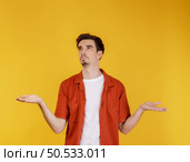 Portrait of puzzled clueless young man arms out asking why what’s the problem who cares so what, I don’t know on isolated background. Стоковое фото, агентство Ingram Publishing / Фотобанк Лори