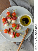 Italian style appetizer, antipasto skewer or caprese on a stick with basil, salami, mozarella and tomatoes. Стоковое фото, агентство Ingram Publishing / Фотобанк Лори