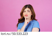 Portrait of young woman wearing casual t-shirt thinking and imagination isolated over pink background. Expression, people and lifestyle concept. Стоковое фото, агентство Ingram Publishing / Фотобанк Лори