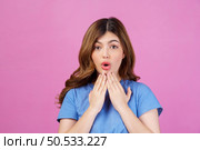 Portrait of excited young woman wearing casual t-shirt surprising isolated over pink background. Expression, people and lifestyle concept. Стоковое фото, агентство Ingram Publishing / Фотобанк Лори