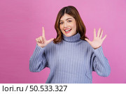Portrait of Happy young woman pointing up with finger number seven isolated over pink background. Lifestyle and emotion concept. Стоковое фото, агентство Ingram Publishing / Фотобанк Лори
