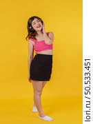Portrait of Happy young woman listening music in headphones and singing while standing isolated over yellow background. Lifestyle and entertainment concept. Стоковое фото, агентство Ingram Publishing / Фотобанк Лори