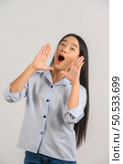 Portrait of young asian woman shout story or making announcement over isolated white background. Advertising and lifestyle concept. Стоковое фото, агентство Ingram Publishing / Фотобанк Лори