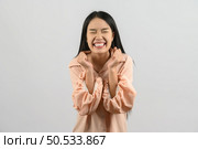 Portrait of Happy young asian woman in pink shirt exciting isolated on white background. Expression and lifestyle concept. Стоковое фото, агентство Ingram Publishing / Фотобанк Лори
