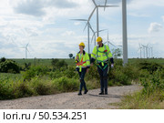 Engineers and wind turbines in a wind farm in the countryside with daily audit tasks mission. Стоковое фото, агентство Ingram Publishing / Фотобанк Лори