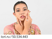 Young beautiful woman dress up in local culture in southern region with beauty posture on her face on white background, copy space. Стоковое фото, агентство Ingram Publishing / Фотобанк Лори