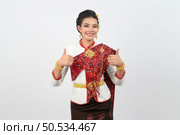 Portrait Young beautiful woman dress up in Thai northeastern region, standing with smile and thumb up, copy space for insert advertise product on white background. Стоковое фото, агентство Ingram Publishing / Фотобанк Лори