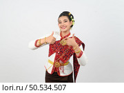 Portrait young pretty woman dress up in beautiful  local culture in northern region with gladtful posture, smile and thumb up on white background, copy space. Стоковое фото, агентство Ingram Publishing / Фотобанк Лори