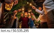 Portrait of Happy Asian group of friends having fun with sparklers outdoor - Young people having fun with fireworks at night time  - People, food, drink lifestyle, new year celebration concept. Стоковое фото, агентство Ingram Publishing / Фотобанк Лори