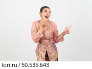 portrait Young beautiful woman dress up in local culture in southern region with excited posture, she point finger and smile with happy on white background, copy space. Стоковое фото, агентство Ingram Publishing / Фотобанк Лори