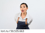 Portrait Asian young woman in waitress uniform standing and open mouth to ask or talk, looking at camera, Free space to insert product for advertising, isolated on white background. Стоковое фото, агентство Ingram Publishing / Фотобанк Лори