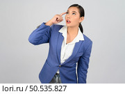 Portrait Asian young woman in officer uniform standing and thinking posture, Cheerful girl with happy smiling and use finger on head, isolated on white background. Стоковое фото, агентство Ingram Publishing / Фотобанк Лори