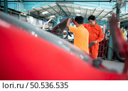 Both of auto mechanics are inspecting the engine of a customer’s car being brought in for repair at a garage. Стоковое фото, агентство Ingram Publishing / Фотобанк Лори