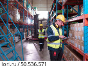 Warehouse foreman and employees Check the imported products in the central warehouse. before delivering to each region’s distribution centers. Стоковое фото, агентство Ingram Publishing / Фотобанк Лори