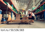 Before exporting to other nations, The product owner meets with the foreman and warehouse personnel to verify their own items held at this warehouse. Стоковое фото, агентство Ingram Publishing / Фотобанк Лори
