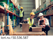 Before exporting to other nations, The product owner meets with the foreman and warehouse personnel to verify their own items held at this warehouse. Стоковое фото, агентство Ingram Publishing / Фотобанк Лори