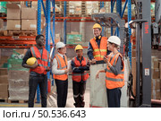 Managers, foremen and warehouse workers Consult together about getting the goods out of the warehouse to finish sending the small merchants tonight. Стоковое фото, агентство Ingram Publishing / Фотобанк Лори