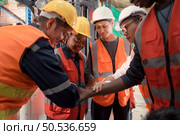 The manager encouraged the warehouse workers to work hard to get the goods out of the warehouse to finish the small merchants tonight. By joining hands and creating a boom. Стоковое фото, агентство Ingram Publishing / Фотобанк Лори