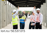 Construction engineers, architects, and foremen form a group. Participate in a meeting to plan new construction projects. Cheers to express happiness that the event was successfully accomplished. Стоковое фото, агентство Ingram Publishing / Фотобанк Лори
