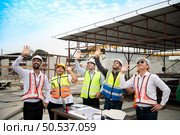 Construction engineers, architects, and foremen form a group. Participate in a meeting to plan new construction projects. Cheers to express happiness that the event was successfully accomplished. Стоковое фото, агентство Ingram Publishing / Фотобанк Лори