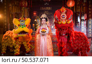 Chinese woman with yellow and red lions It is considered to enhance the prosperity for oneself on the occasion of the Chinese New Year festival every year and in Chinese, it means prosperous, fortunate, happy, prosperous. Стоковое фото, агентство Ingram Publishing / Фотобанк Лори