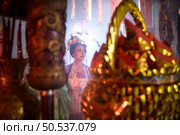 Chinese woman make wishes, pray, and light candles. On the occasion of the annual Chinese New Year festival, in a revered shrine or temple, And in Chinese where candles mean good luck and happiness. Стоковое фото, агентство Ingram Publishing / Фотобанк Лори