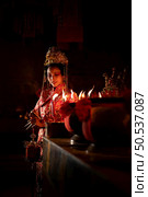 Chinese woman make wishes, pray, and light candles. On the occasion of the annual Chinese New Year festival, in a revered shrine or temple, And in Chinese where candles mean good luck and happiness. Стоковое фото, агентство Ingram Publishing / Фотобанк Лори