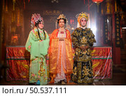 Male and female Chinese opera actors Light a candle to pray homage to the gods to enhance the prosperity for yourself on the occasion of the Chinese New Year festival. Стоковое фото, агентство Ingram Publishing / Фотобанк Лори