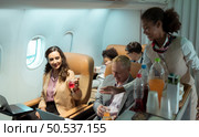 Flight attendant serving food and drinks to passengers. Стоковое фото, агентство Ingram Publishing / Фотобанк Лори