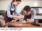 Before competing in the championship level coffee brewing competition, both of the baristas practice their coffee latte makeup techniques to become proficient. Стоковое фото, агентство Ingram Publishing / Фотобанк Лори