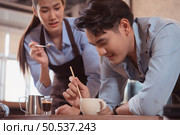 Before competing in the championship level coffee brewing competition, both of the baristas practice their coffee latte makeup techniques to become proficient. Стоковое фото, агентство Ingram Publishing / Фотобанк Лори