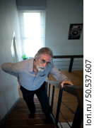 The old man had to fend for himself without his children taking care of him. Have severe back pain create difficulty in going up the stairs at home. Стоковое фото, агентство Ingram Publishing / Фотобанк Лори