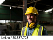 Chief mechanical engineer working in a mechanical factory make radio communication control with walkie-talkie and follow up with Asian technicians who are repairing old machines. Стоковое фото, агентство Ingram Publishing / Фотобанк Лори