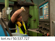 Asian mechanic working in a mechanical factory Repairing old machines to bring them back to normal operation. Стоковое фото, агентство Ingram Publishing / Фотобанк Лори