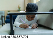 little boy with imagination who scribbled or drew what they thought on the paper with joy and fun. Стоковое фото, агентство Ingram Publishing / Фотобанк Лори