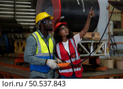 Two technicians Inspecting and testing the operation of lifting cranes in heavy industrial plants. Стоковое фото, агентство Ingram Publishing / Фотобанк Лори