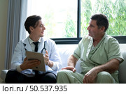 A young doctor who specializes in heart disease. Report and advise patients with symptoms of heart disease. that the results of the treatment improved until they were able to go home tomorrow. Стоковое фото, агентство Ingram Publishing / Фотобанк Лори