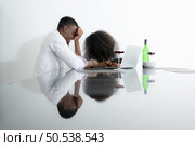 Both of young businesses drinking wine and use their laptops to share information with each other in their living room of house. Стоковое фото, агентство Ingram Publishing / Фотобанк Лори