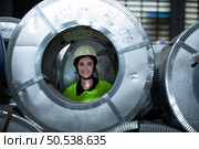 Portrait of a heavy equipment female engineer from a huge industry who came to inspect the metal sheet factory’s machinery. Стоковое фото, агентство Ingram Publishing / Фотобанк Лори