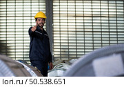 Portrait of a heavy equipment male engineer from a huge industry who came to inspect the metal sheet factory’s machinery. Стоковое фото, агентство Ingram Publishing / Фотобанк Лори