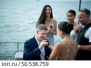 The appropriate time for a white man to propose to marry an Asian woman. on a yacht floating in the lovely water. Among friends who joined in congratulating. Стоковое фото, агентство Ingram Publishing / Фотобанк Лори