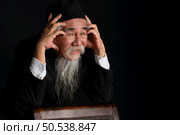 Portrait of a wrinkled-faced old man with a long white beard on a black background, studio shot. Стоковое фото, агентство Ingram Publishing / Фотобанк Лори