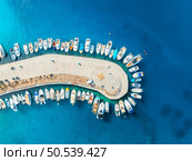 Aerial view of boats and luxury yachts in dock at sunset in summer in Krk island, Croatia. Colorful landscape with sailboats and motorboats in sea bay, jetty, clear blue sea. Top view of harbor. Стоковое фото, агентство Ingram Publishing / Фотобанк Лори