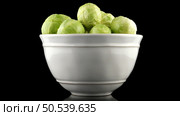 Fresh brussels sprouts on white ceramic bowl isolated on black background. Стоковое фото, агентство Ingram Publishing / Фотобанк Лори