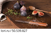 Fresh figs. Whole figs and sliced in half figs on wooden cutting board. Стоковое фото, агентство Ingram Publishing / Фотобанк Лори