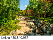 Park landscape with a pedestrian path and a man -made stream in a public park in the city of Krasnodar. Стоковое фото, фотограф Владимир Ушаров / Фотобанк Лори
