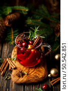 Christmas mulled wine with cranberry, orange, cinnamon, anise and rosemary. Traditional hot drink or beverage, festive Xmas or New Year winter cocktail. Стоковое фото, агентство Ingram Publishing / Фотобанк Лори
