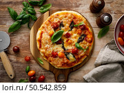 Pizza Margherita on a wooden background. Стоковое фото, агентство Ingram Publishing / Фотобанк Лори