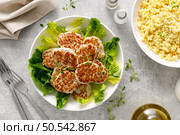 Chicken patties, cutlets with fresh romaine lettuce salad and couscous, top down view. Стоковое фото, агентство Ingram Publishing / Фотобанк Лори